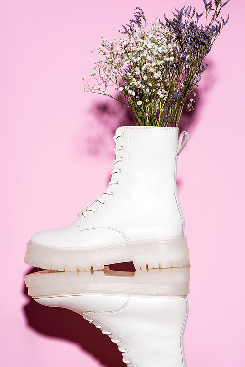 white boots with wildflowers on pink background