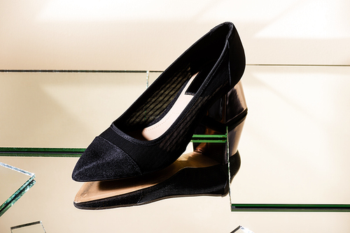 elegant black heeled shoe on mirror surface