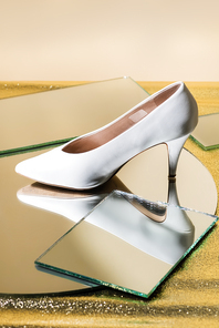 elegant white heeled shoe on mirror surface