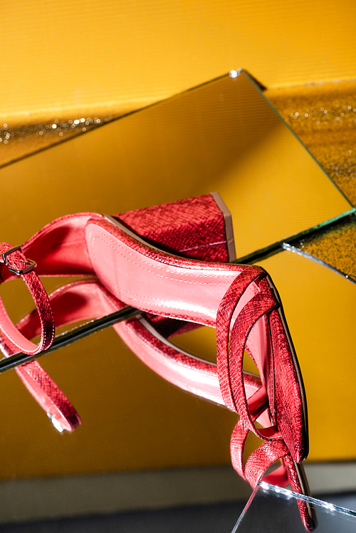 elegant pink snakeskin heeled sandals on mirror surface