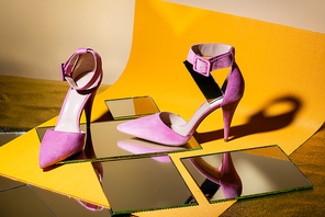 elegant violet suede heeled shoes on mirror and yellow paper