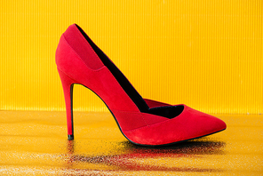 elegant red suede heeled shoe on yellow background