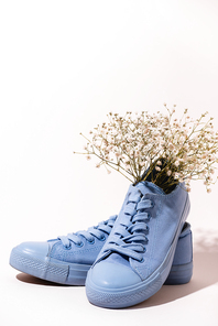 casual blue sneakers with wildflower on white background