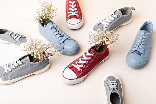 casual sneakers and wildflowers on white background