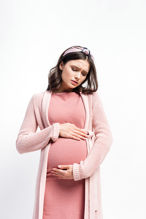 sad pregnant woman in headband touching belly isolated on white