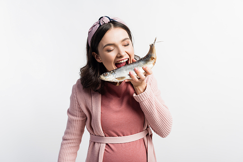 pregnant woman with open mouth and closed eyes holding dried fish isolated on white