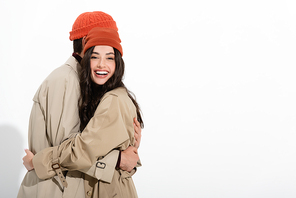 trendy woman in beanie hat hugging man on white