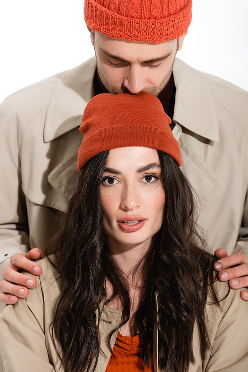 man in beanie hat kissing head of young woman isolated on white