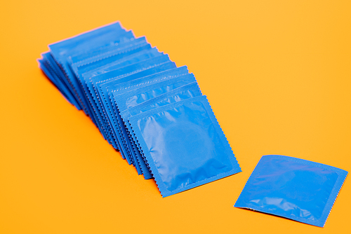 blue packs with condoms isolated on orange