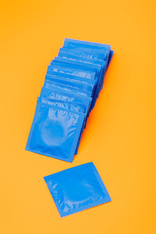 condoms in blue packs isolated on orange