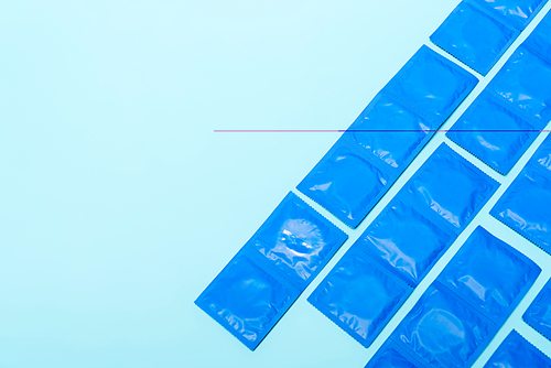 top view of packs with condoms isolated on blue with copy space
