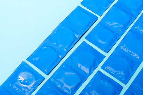packs with contraceptive condoms isolated on blue with copy space