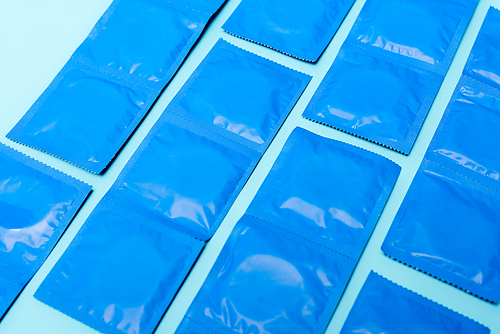 packs with contraceptive condoms isolated on blue