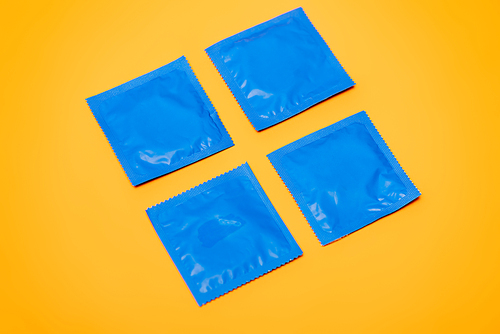 blue packs with contraceptive condoms isolated on orange