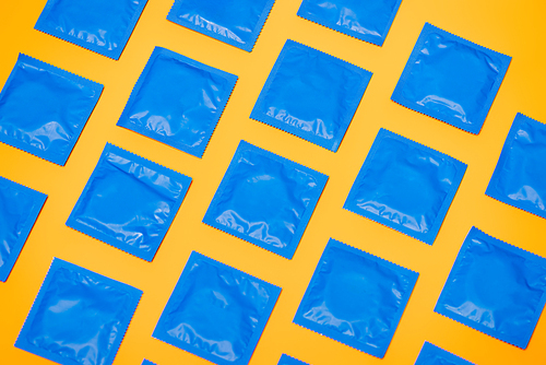top view of blue packs with condoms isolated on orange
