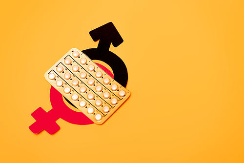 top view of blister pack with contraceptive pills and gender symbols isolated on orange