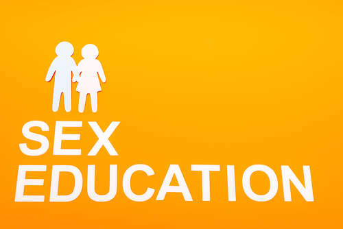 top view of sex education lettering near paper people isolated on orange