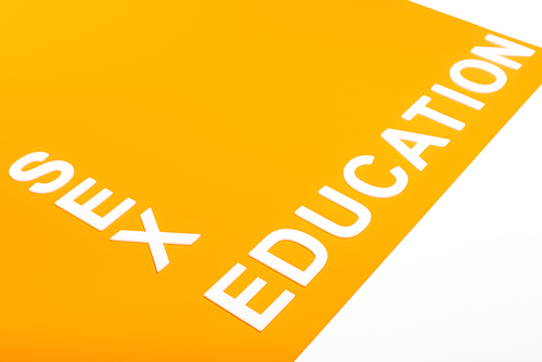 sex education lettering on orange surface isolated on white