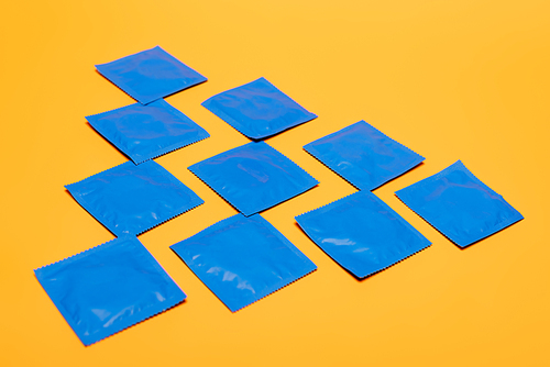 flat lay with condoms in blue packs isolated on orange