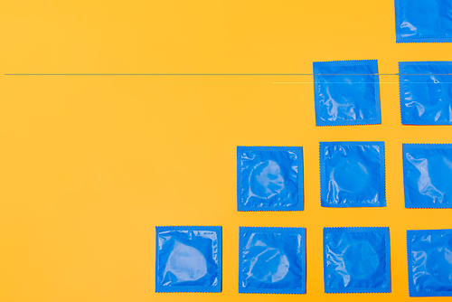 top view of condoms isolated on orange with copy space