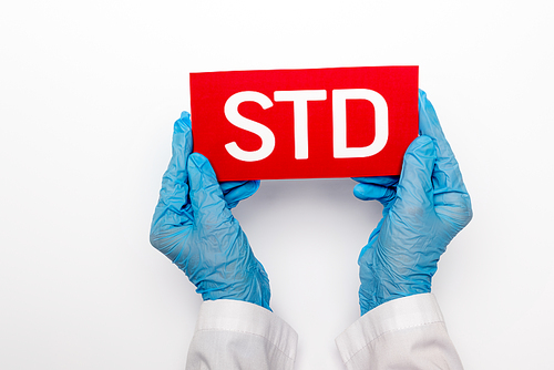 top view of doctor in blue latex gloves holding paper with std lettering isolated on white