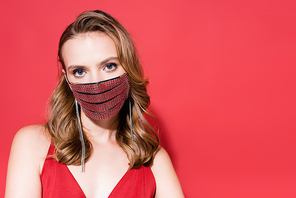 young woman in protective mask with rhinestones  on red