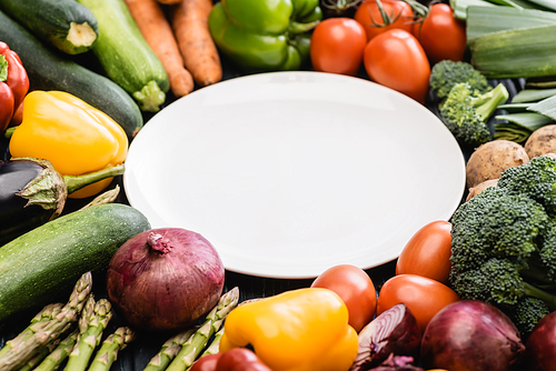 round empty plate and ripe colorful vegetables