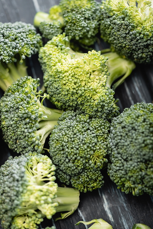 close up view of fresh green broccoli on wooden surface