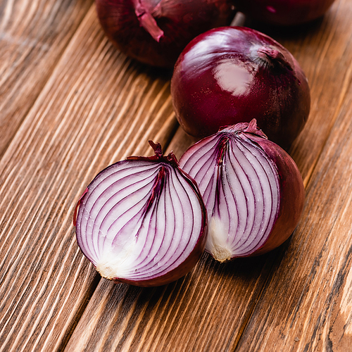 close up view of red onion halves on wooden table