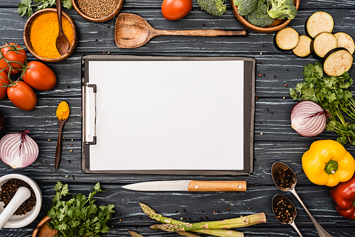 top view of fresh colorful vegetables and spices near blank clipboard on wooden surface