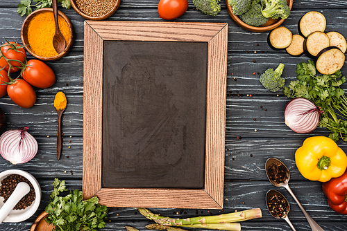 top view of fresh colorful vegetables and empty chalkboard on wooden table