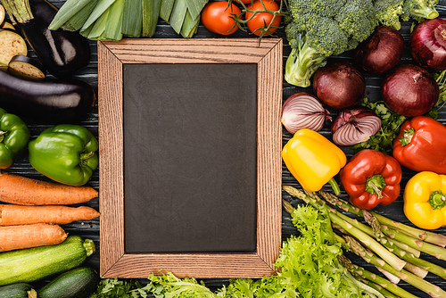 top view of fresh colorful vegetables around empty chalkboard
