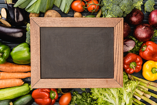 top view of fresh colorful vegetables around empty chalkboard