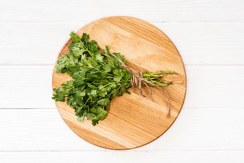 top view of parsley on chopping board on white wooden table