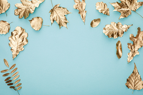 top view of autumnal golden leaves on blue background