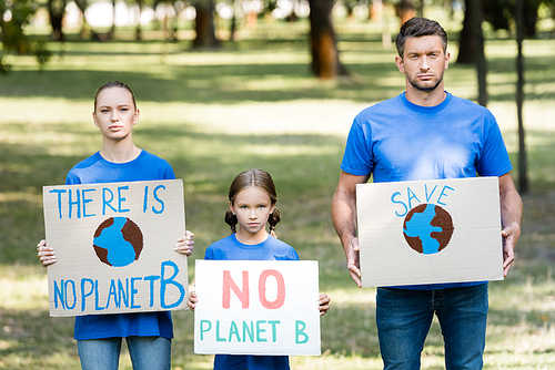 couple with daughter holding placards with globe, save, and there is no planet b inscription, ecology concept