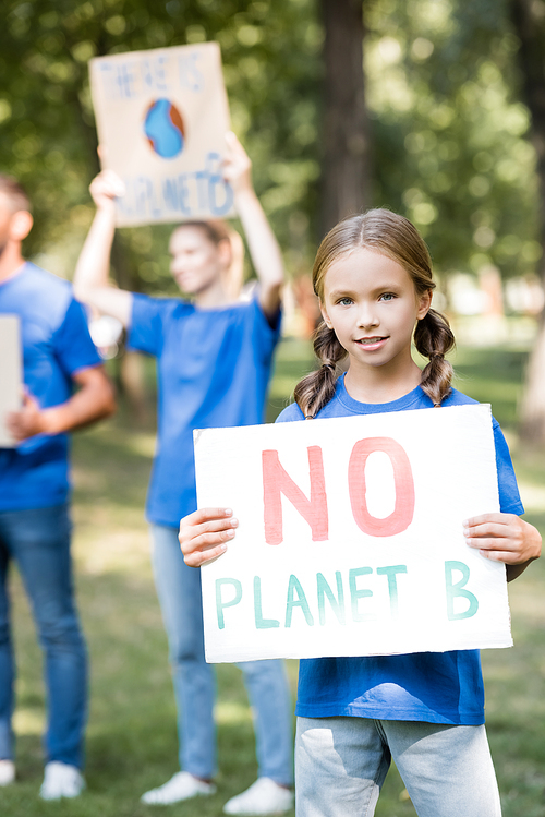girl holding placard with no planet b inscription near family with posters on blurred background, ecology concept