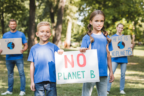 children holding placard with no planet b inscription near parents with posters on blurred background, ecology concept