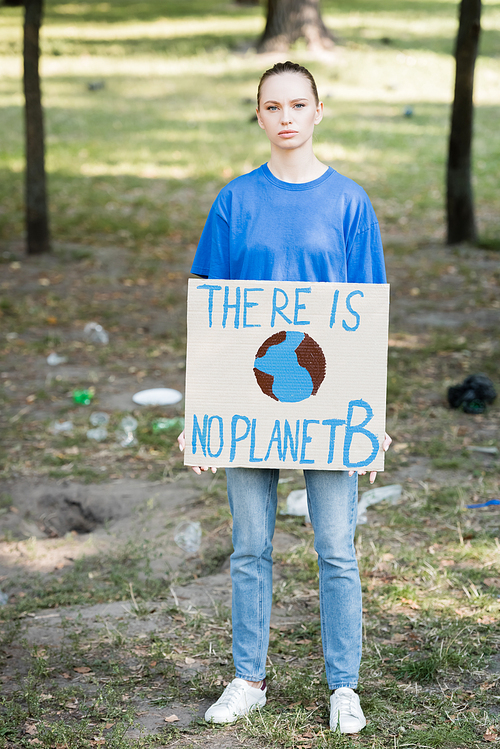 woman  while holding placard with globe and there is no planet b inscription