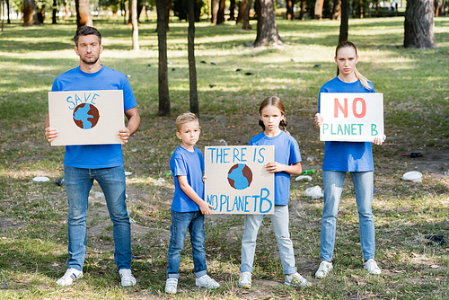 two children and parents holding posters with globe and there is no planet b inscription, ecology concept