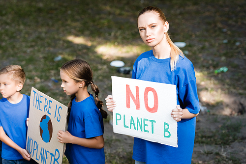 woman and children holding placards with no planet b inscription, ecology concept