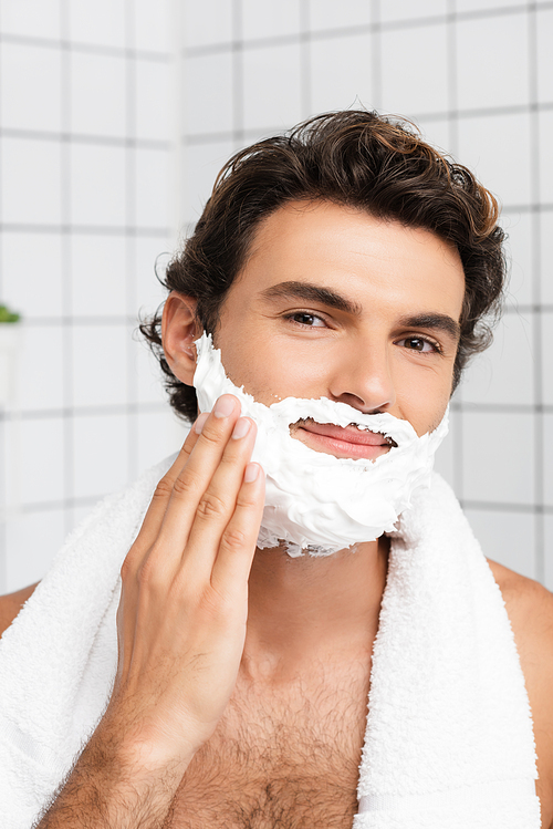 Smiling man  while applying shaving foam