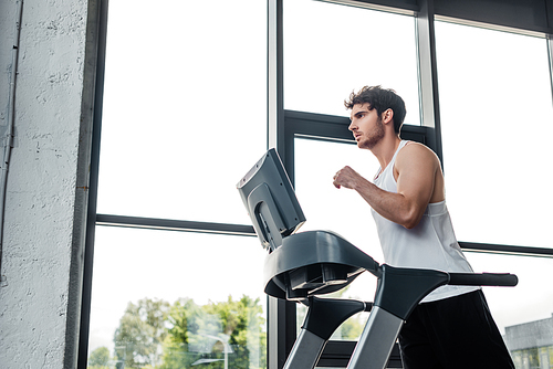 handsome man in sportswear running on treadmill