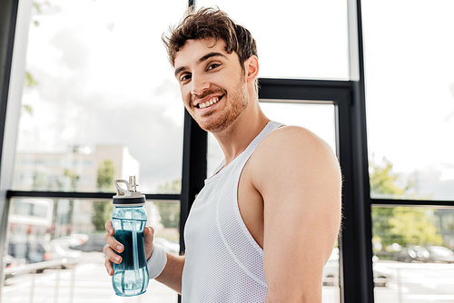 happy sportsman holding sports bottle with water