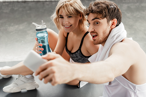 selective focus of sport couple taking selfie in gym