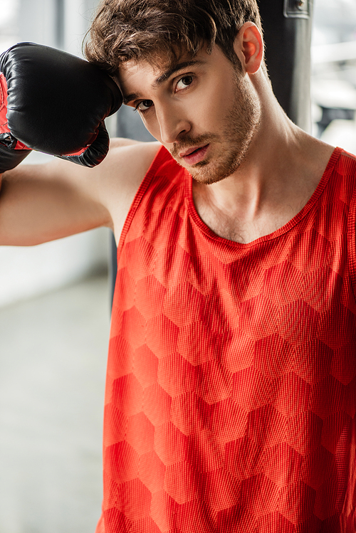 tired man in sportswear and boxing glove touching face