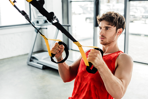 handsome sportsman exercising with elastics in gym