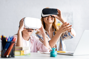 Selective focus of excited kid using vr headset near mother during online education