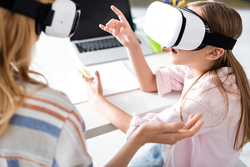 Selective focus of mother and excited kid using vr headsets at home