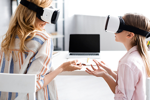 Smiling woman using vr headsets with daughter at home